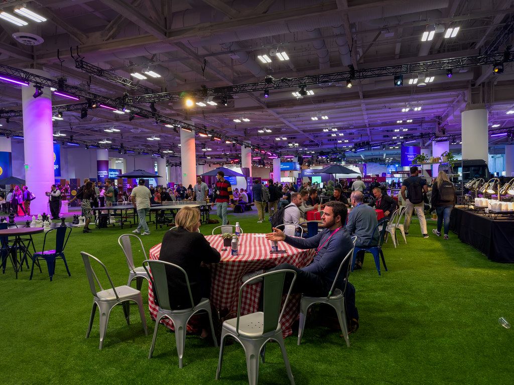 Attendees networking at tables in a technology conference hall